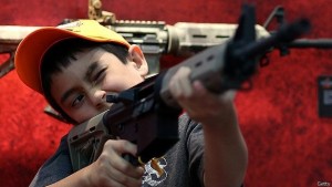 Un niño sostiene un arma durante la convención anual de la Asociación Nacional del Rifle de EE.UU. (NRA).