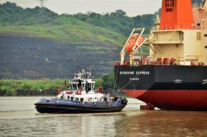 Un remolcador guía a un buque en tránsito en aguas del Canal de Panamá. (Foto: ACP).